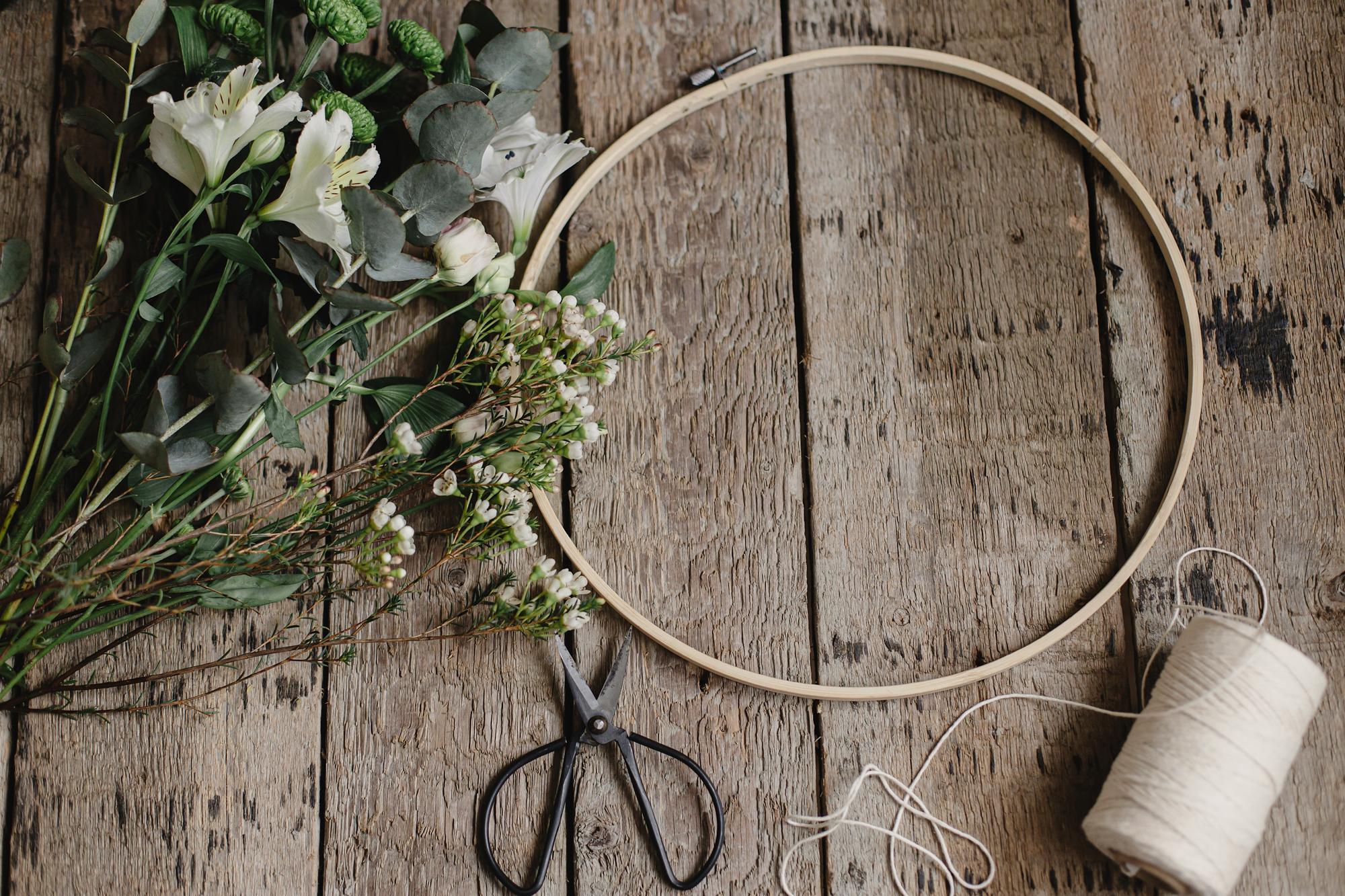 Artisan stitching floral hoop in warm studio